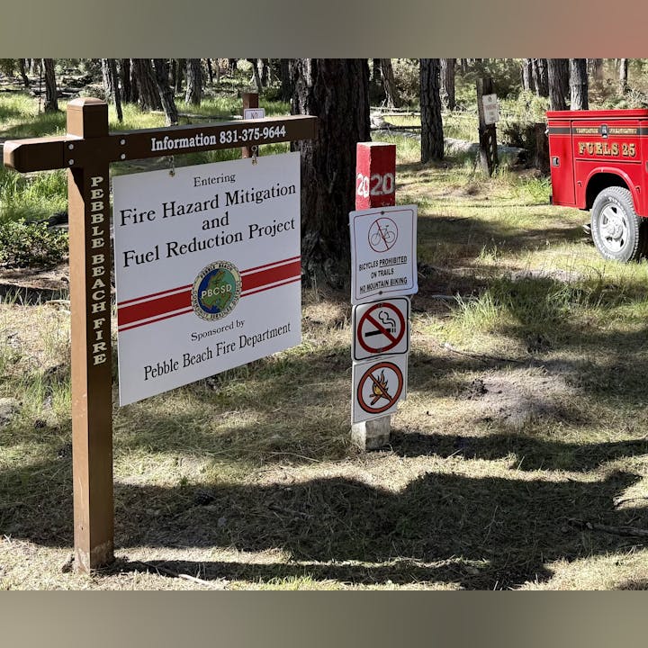 Sign for Pebble Beach Fire's hazard mitigation project; bicycles prohibited, no smoking or fires.