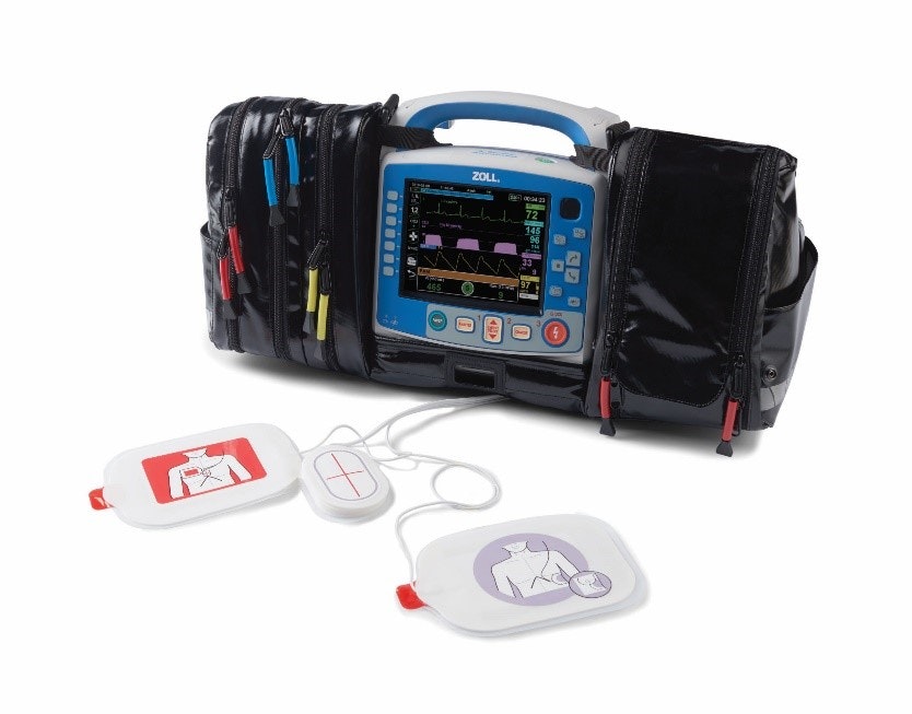 Medical defibrillator with a screen, electrodes, and colored zipper pouches.