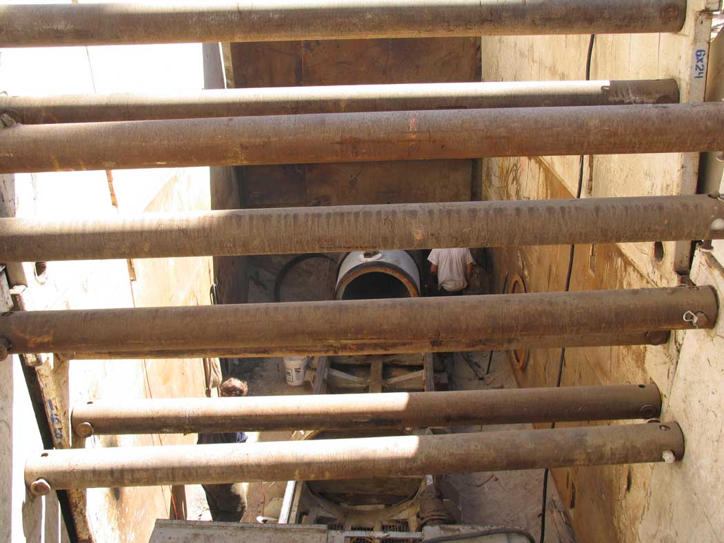 Metal scaffolding overlooking a construction site with a worker visible below.