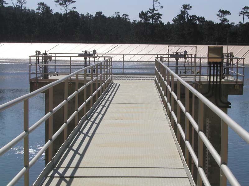 A walkway leading to mechanical structures on a water treatment facility.