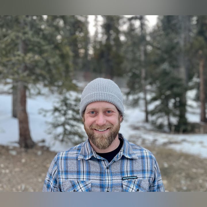 May contain: cap, clothing, hat, face, head, person, photography, portrait, adult, male, man, plant, tree, vegetation, happy, smile, and shirt