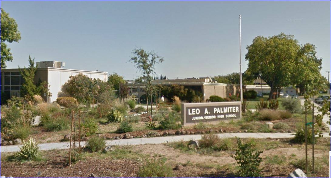 A school facade with garden and sign reading "Leo A. Palmiter Junior/Senior High School."