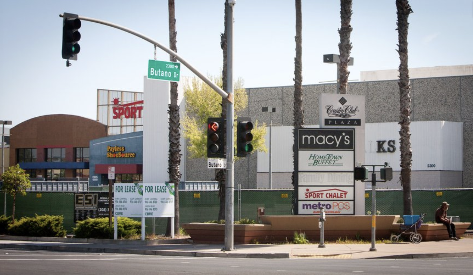 Street scene from 2008/2009 with traffic lights and signs for Macy's, Payless ShoeSource, Sport Chalet, and more at Country Club Plaza, Butano Drive.