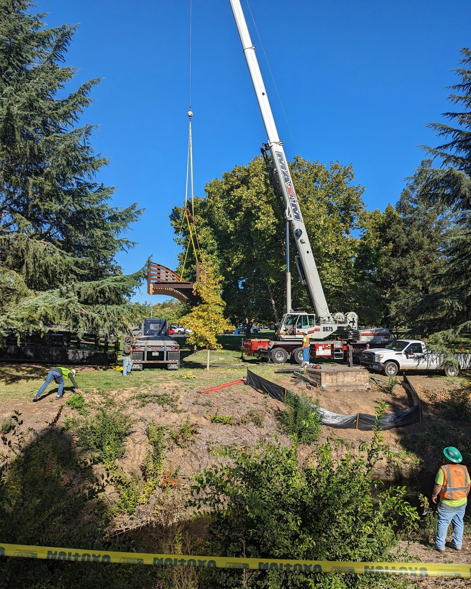 May contain: helmet, person, pickup truck, transportation, truck, vehicle, construction, clothing, footwear, shoe, construction crane, plant, tree, and car