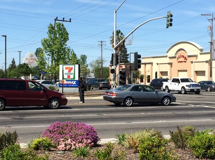 May contain: vehicle, transportation, automobile, car, light, traffic light, road, person, human, machine, wheel, spoke, tire, urban, building, town, street, and city