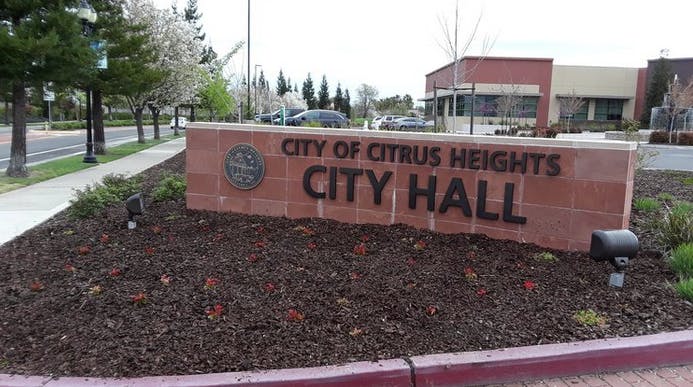 Sign for the City Hall of Citrus Heights, featuring landscaping and nearby buildings.