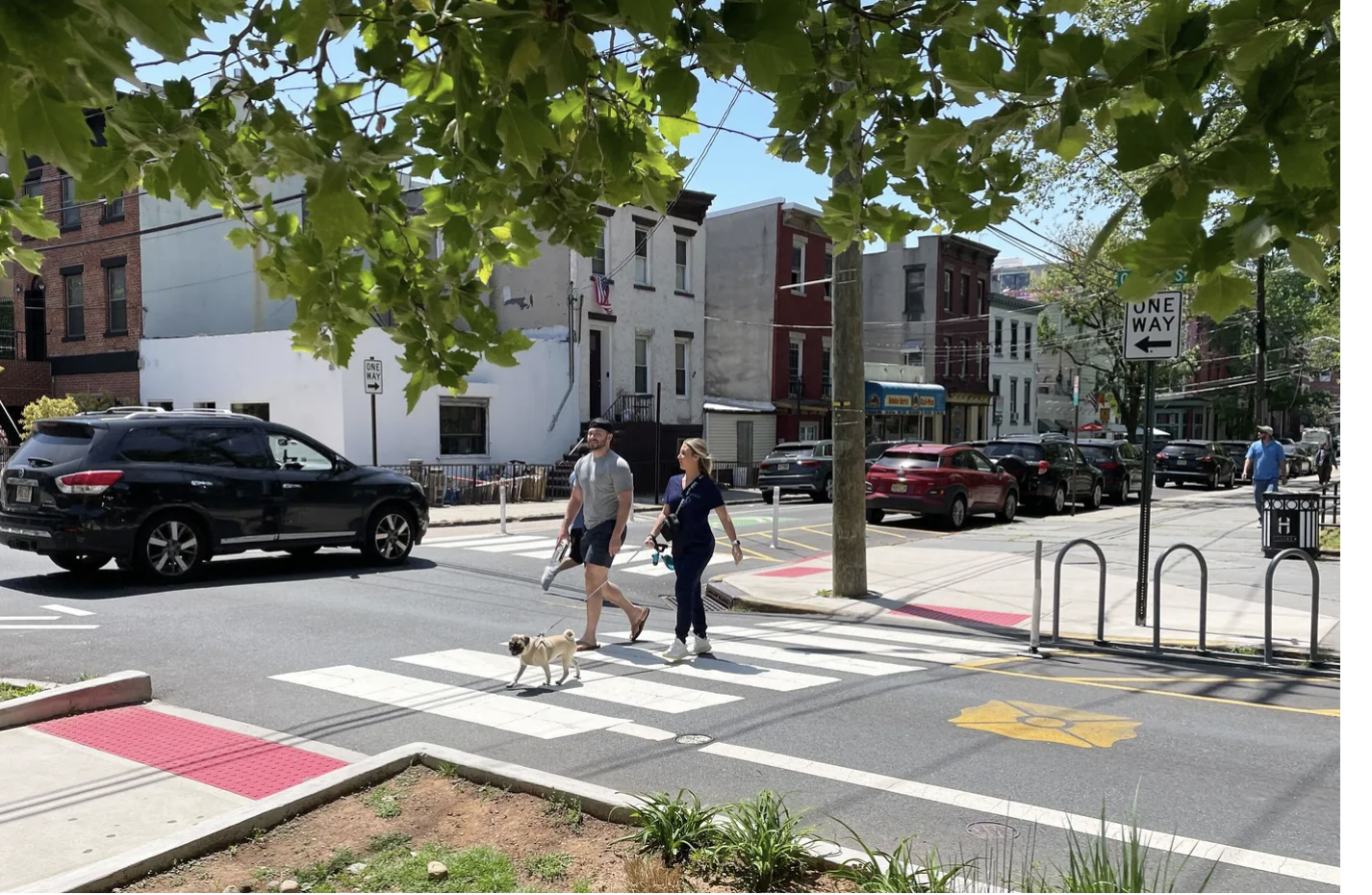 May contain: road, tarmac, asphalt, pedestrian, person, human, dog, mammal, animal, canine, pet, car, transportation, vehicle, automobile, intersection, zebra crossing, wheel, machine, and path