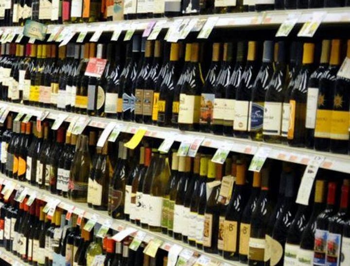 The image shows a grocery store wine aisle filled with various bottles of wine, all labeled with different brands and prices.