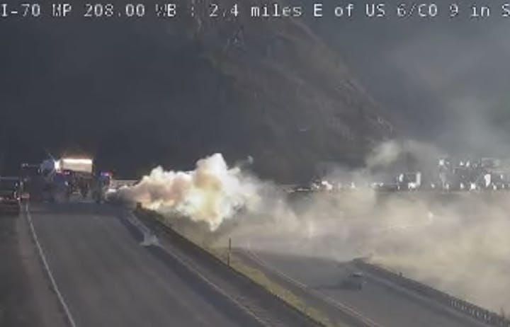 A highway with emergency vehicles and thick smoke visible, indicating possible fire or accident.