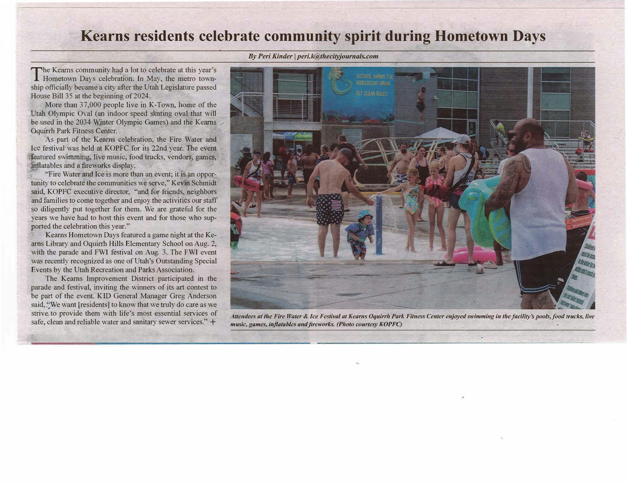 Community celebration at a pool with inflatables, food, and people enjoying a sunny day.