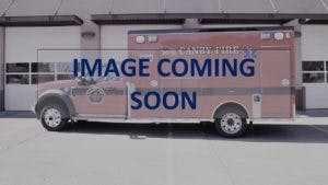 The image shows a fire department ambulance parked outside a garage, with a placeholder text indicating "IMAGE COMING SOON."