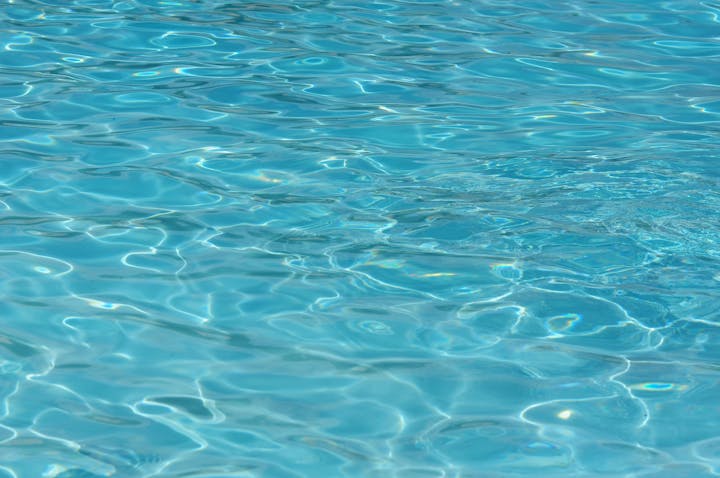 Crystal clear swimming pool water with ripples.