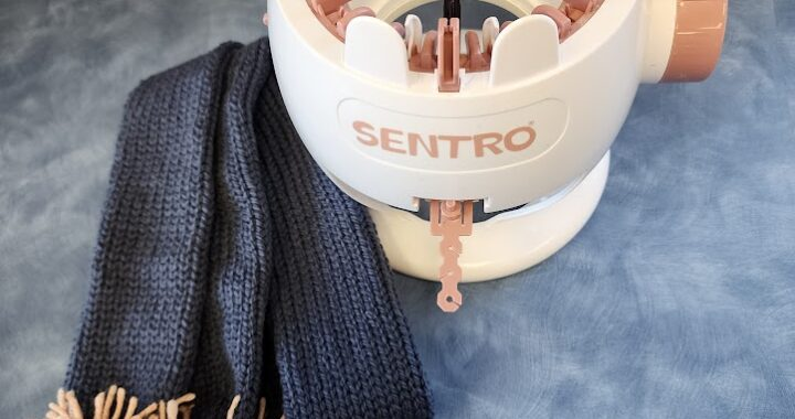 A Sentro knitting machine with a partially completed blue knit project.