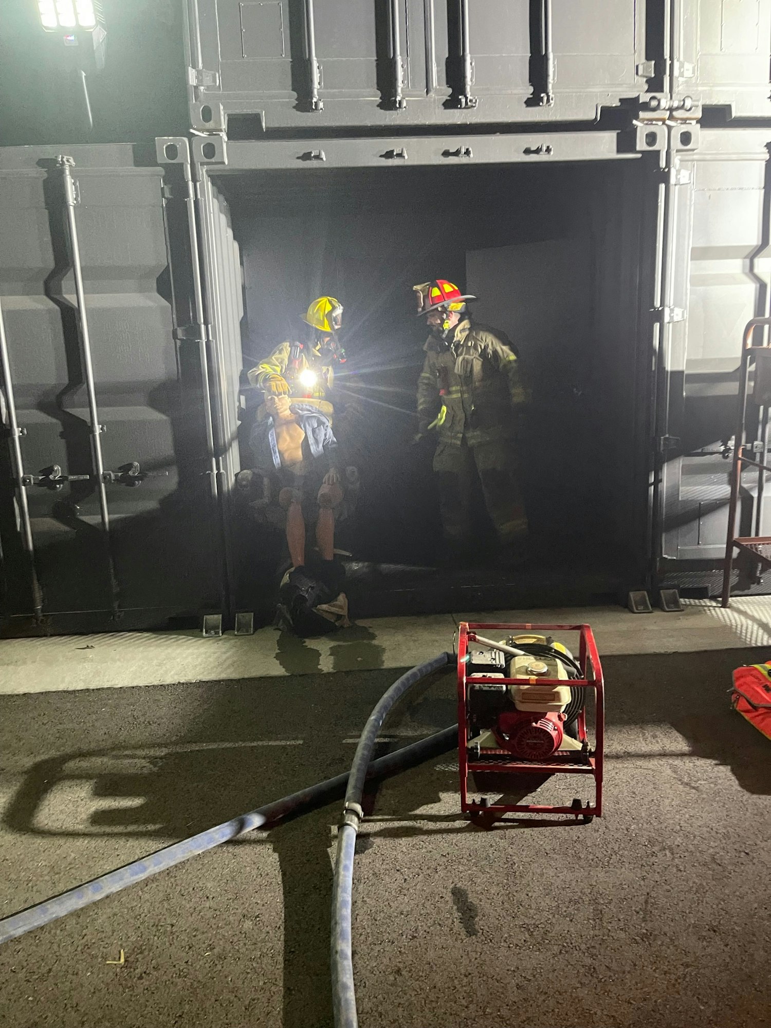 Firefighters with equipment during a night operation. (Note: Image is rotated clockwise)