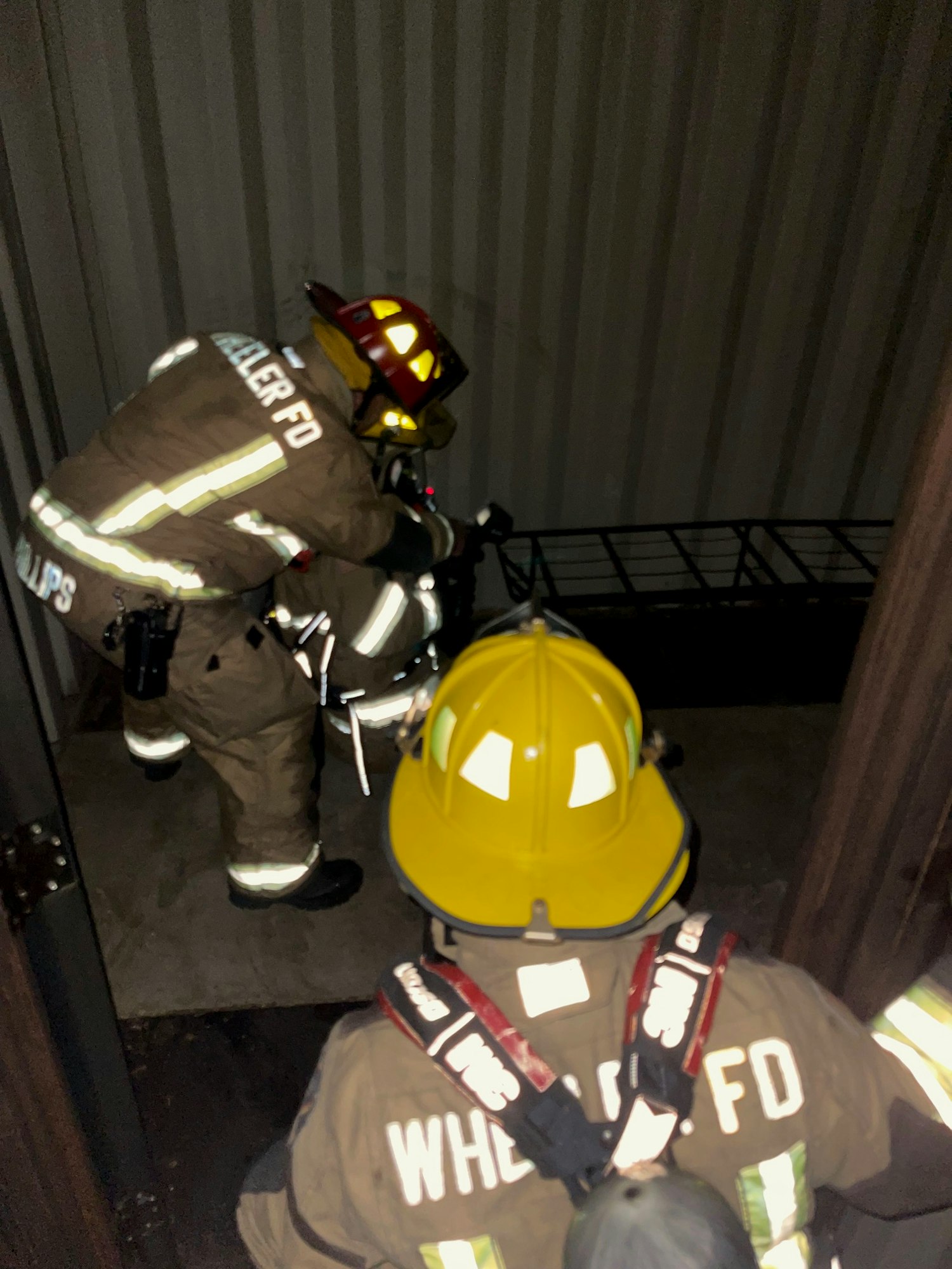 Firefighters with gear, possibly during a training exercise or emergency response. Image is rotated, dark and slightly unclear.