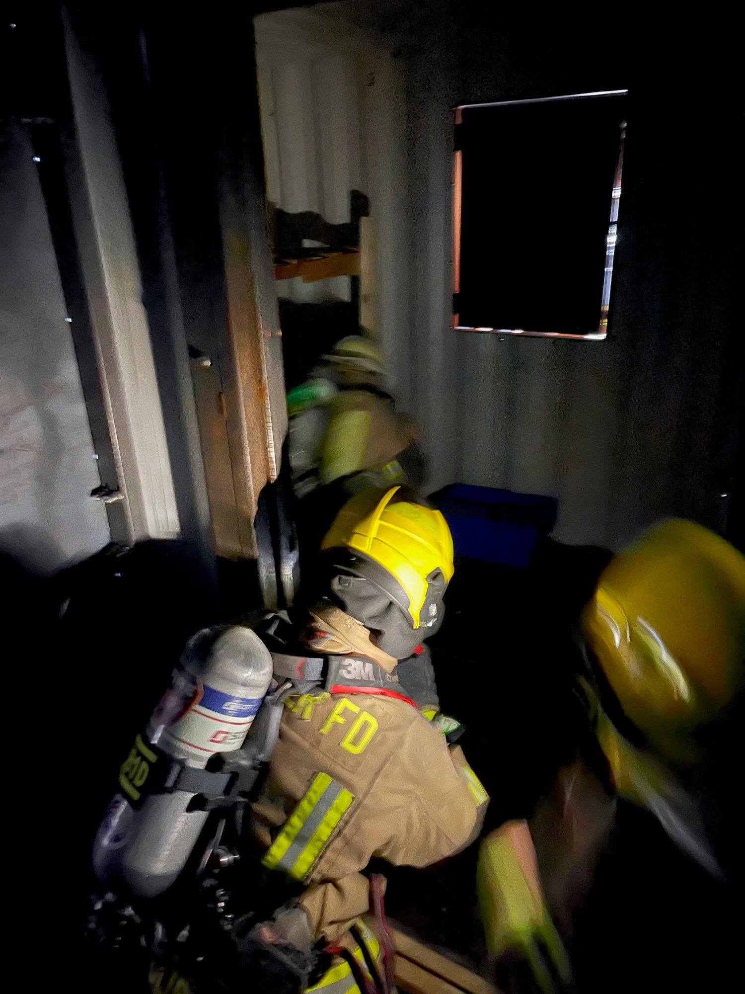 A blurred action shot of a firefighter in gear inside a vehicle, possibly during emergency response.