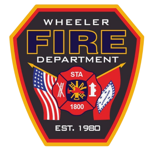 The image is a badge of the Wheeler Fire Department, featuring the department name, established date (1980), and state flags.