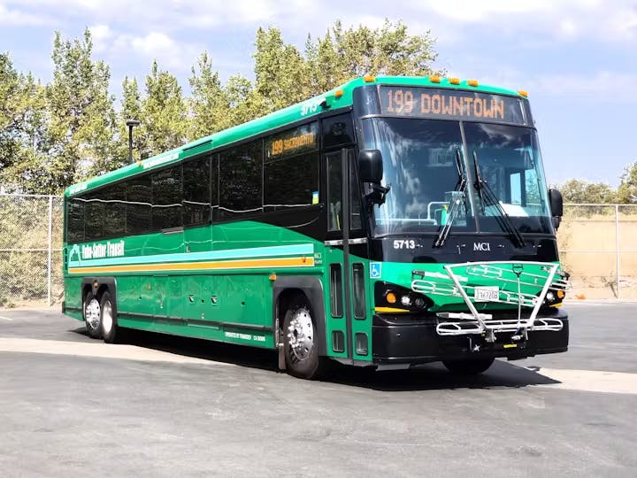 A green transit bus labeled "199 Downtown" parked outdoors.