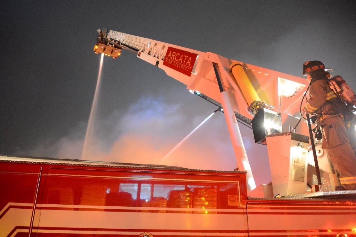 Fire fighter operating a ladder truck master stream.