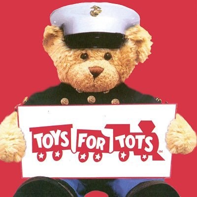 Teddy Bear in Marine Corp Uniform holding a Toys for Tots banner