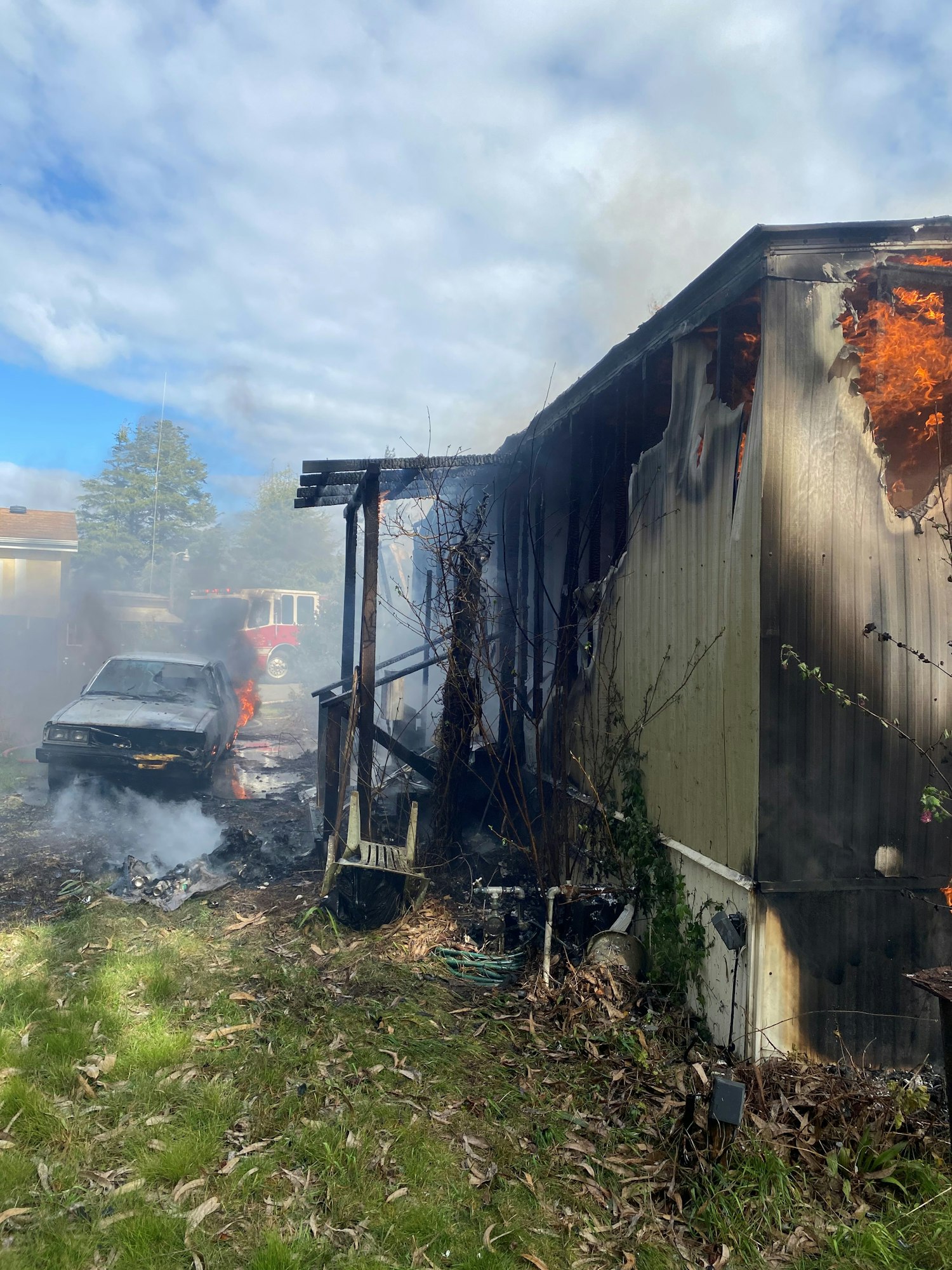 Vehicle next to mobile home on fire