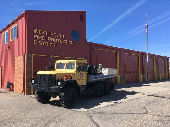Fire station with a fire truck outside and an American flag.