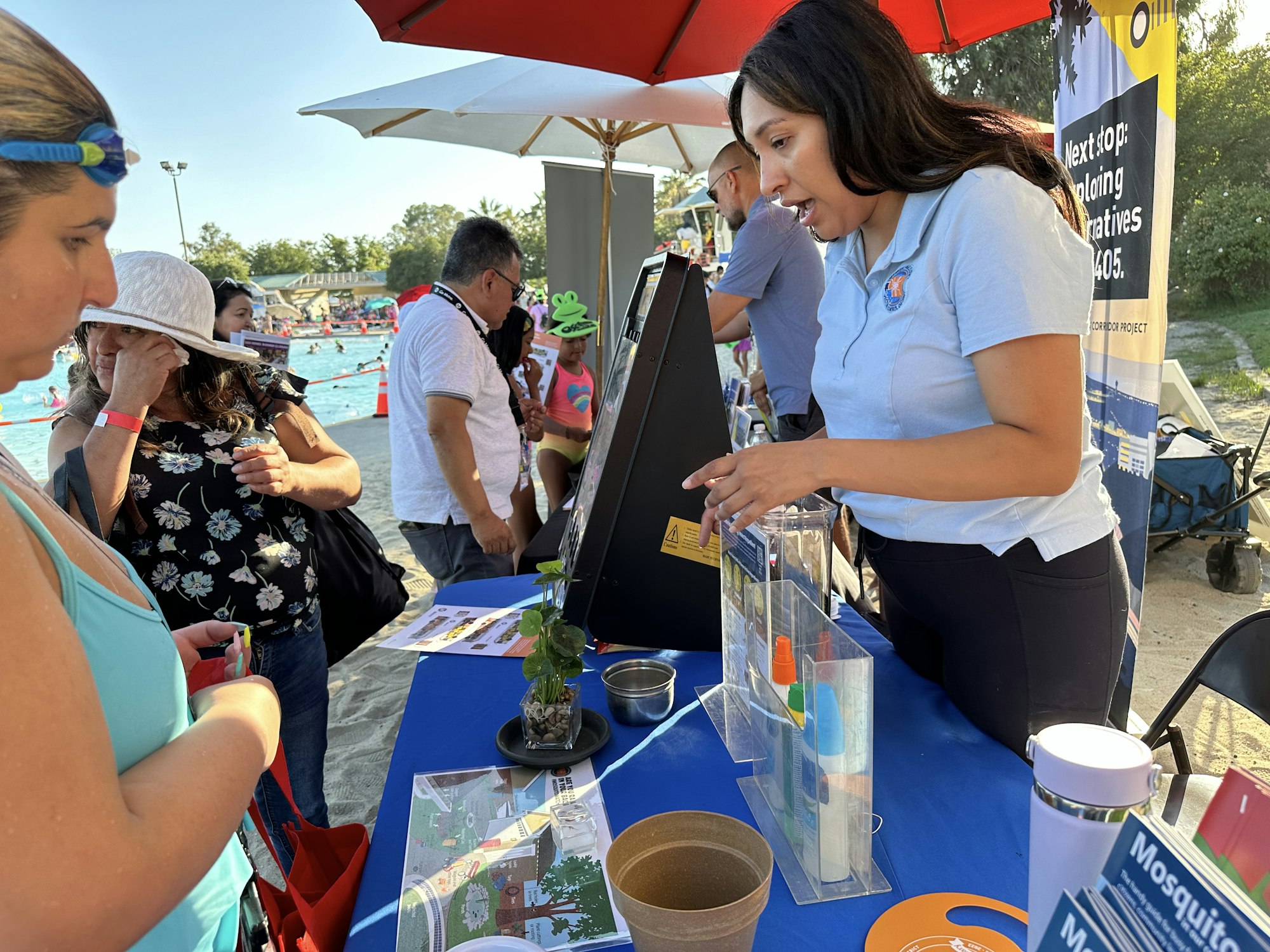 People at an outdoor event with informational booths and exhibits, engaging with educational displays.