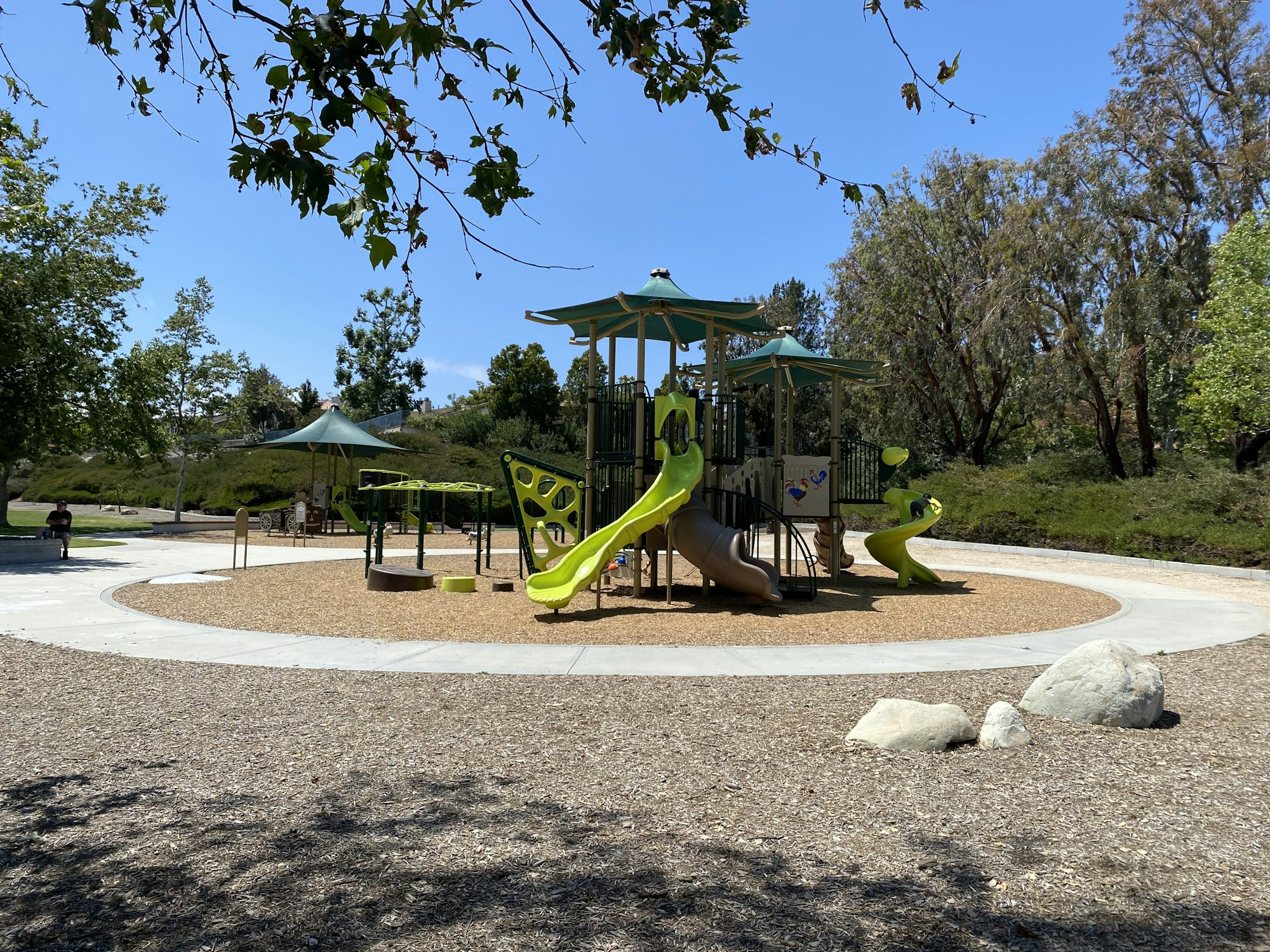 May contain: grass, nature, outdoors, park, plant, outdoor play area, play area, person, bench, and furniture