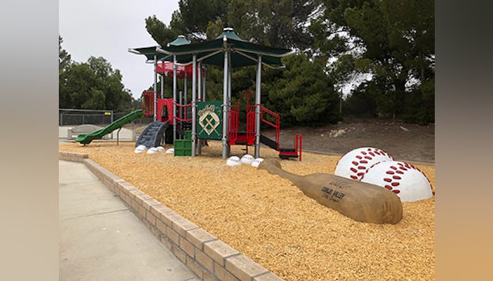 Children's playground with slides, a mini climbing wall, and a theme resembling a baseball field.