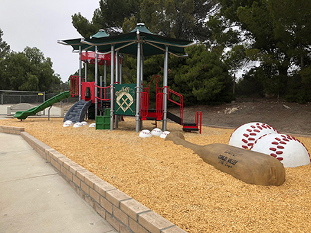 Children's playground with slides, a mini climbing wall, and a theme resembling a baseball field.