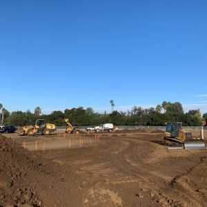 A construction site with construction vehicles and equipment on a clear day.