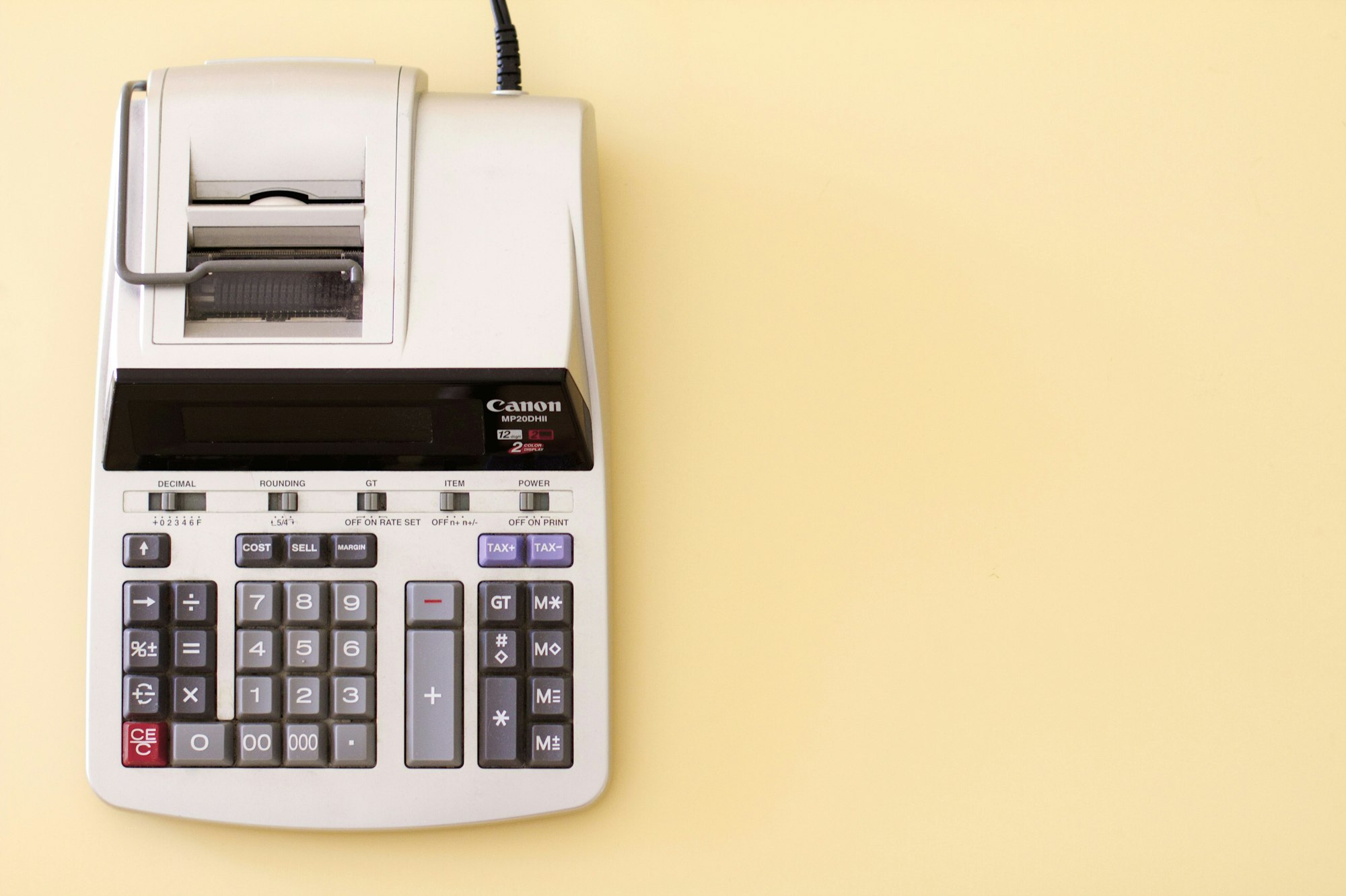 A Canon printing calculator on a yellow background.