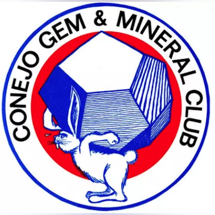 A rabbit carrying a large gem with the words "Conejo Gem & Mineral Club" in a circular logo.
