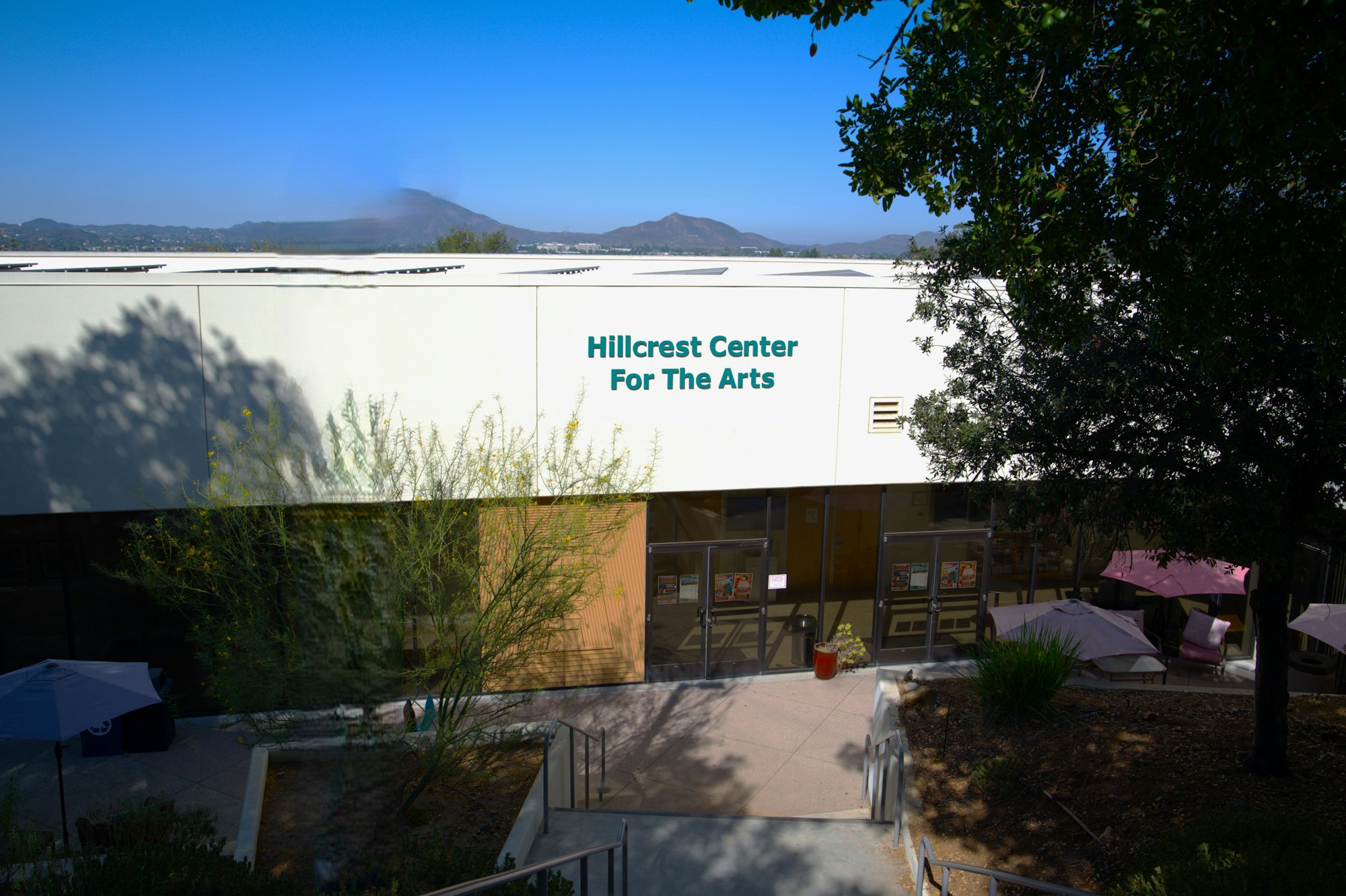 Exterior of Hillcrest Center for the Arts, with steps, trees, and a mountain in the background.