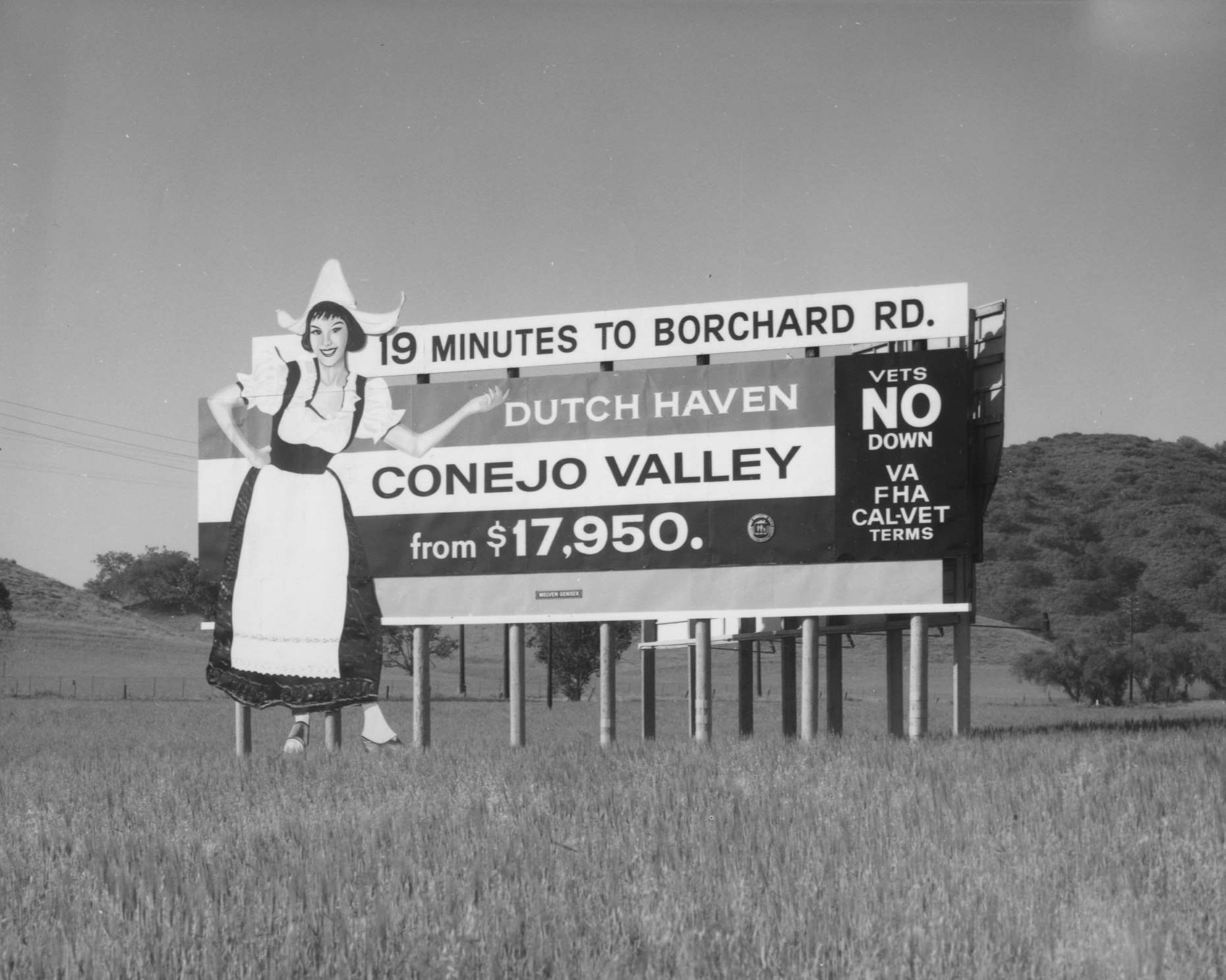A billboard advertises Dutch Haven Conejo Valley homes from $17,950, featuring a woman in traditional dress.