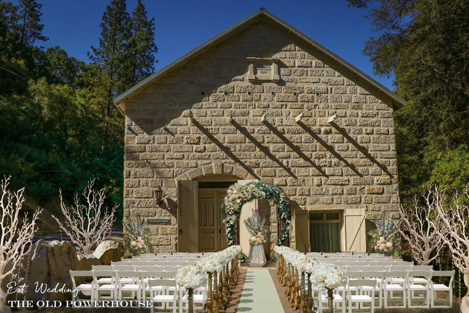 Outdoor wedding setup with chairs and a floral arch in front of an old stone building.
