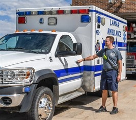 A paramedic standing next to an ambulance.