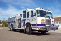 A firetruck parked outdoors under a clear sky.