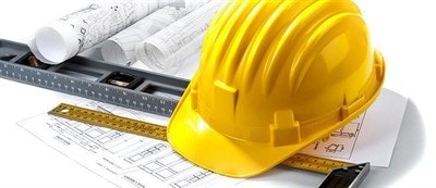 Hard hat, architectural plans, and measuring tools on a white background.
