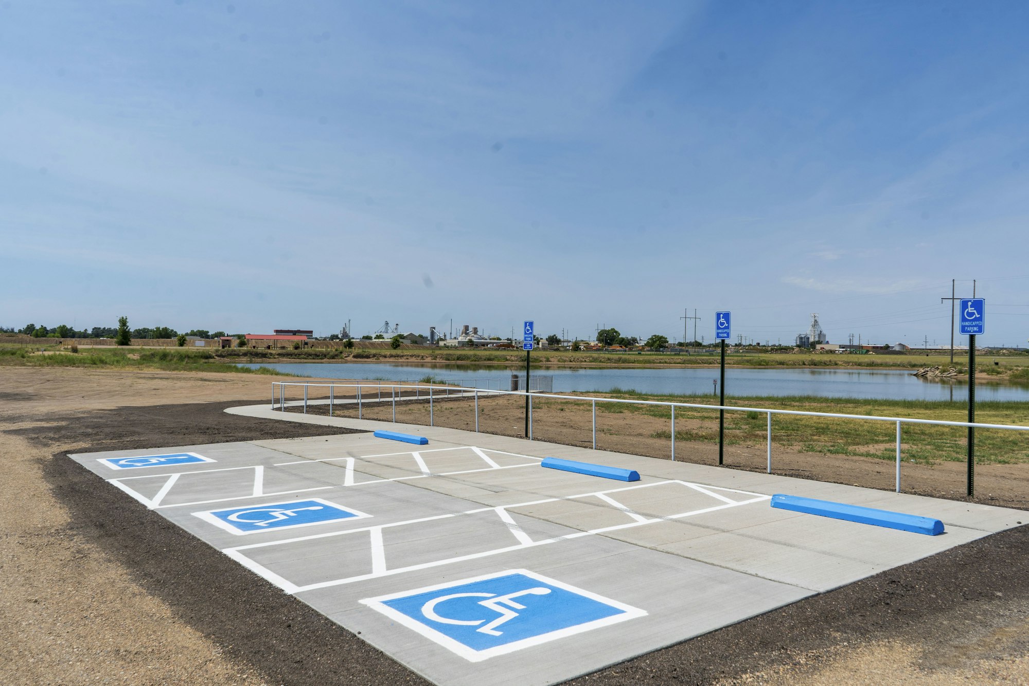 Accessible parking spaces near a body of water, with clear signage and markings.