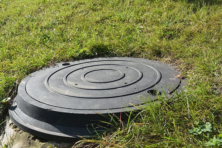 Manhole cover on grassy ground.