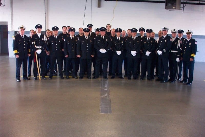 A group of uniformed officers posing together indoors in a formation.