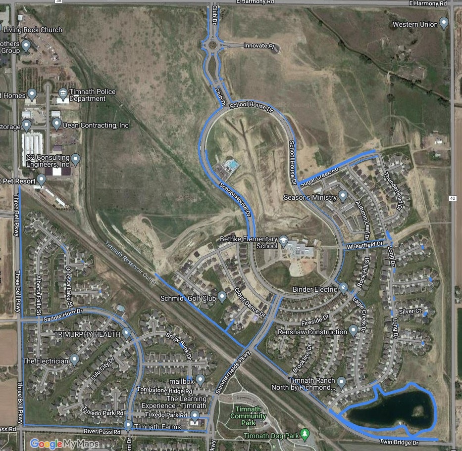 A satellite view of a suburban area with streets, buildings, a river, and labels indicating businesses and landmarks.