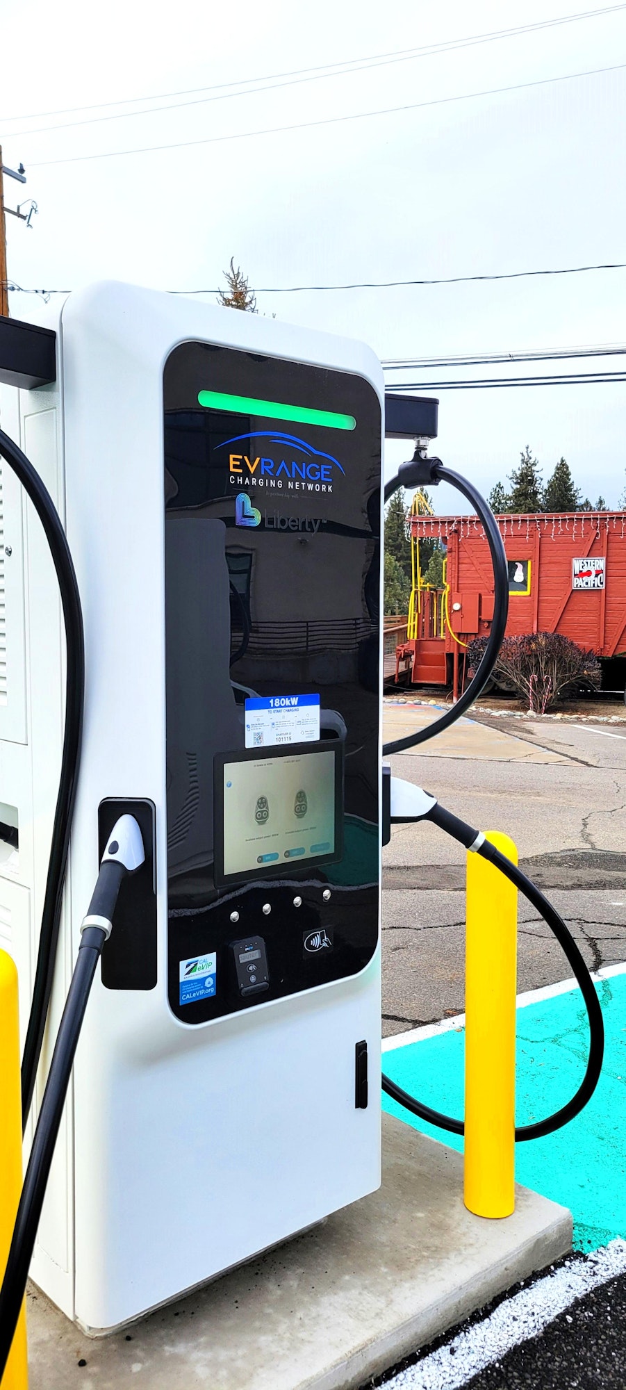 Electric vehicle charging station with digital screen and charging cables attached.