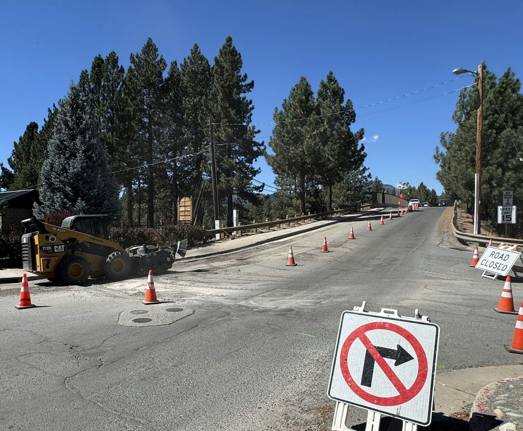 Roadwork with traffic cones, construction vehicle, no right turn, and road closed signs.