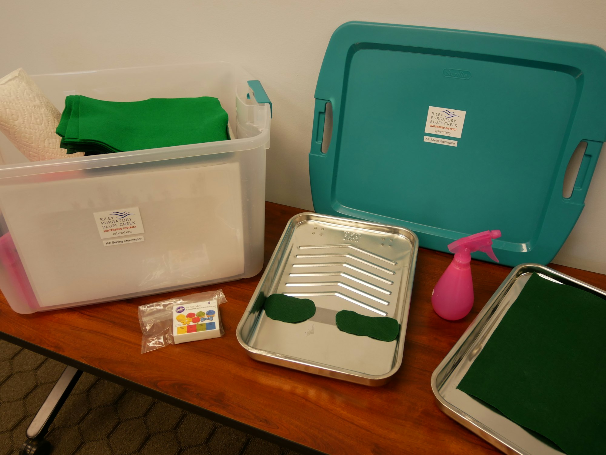 Storage container with green lid, green fabric inside, a tray, spray bottle, two green cutouts, and an instruction sheet.