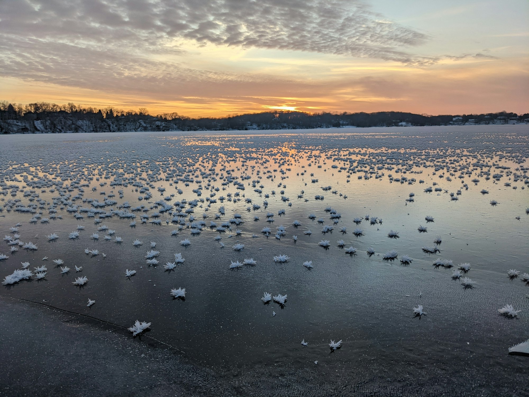 Frozen lake with ice crystals at sunrise.