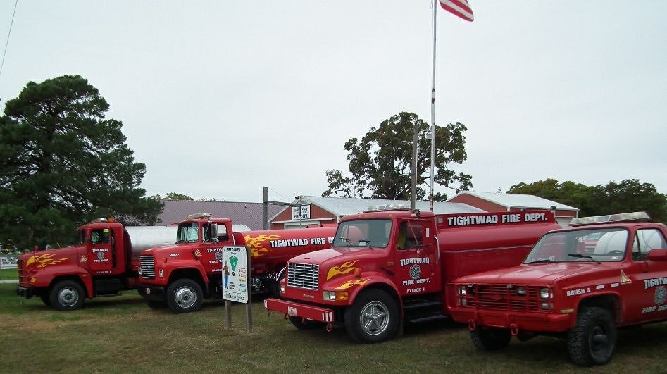 Tightwad Fire Protection District vehicles parked in front of a USA flag