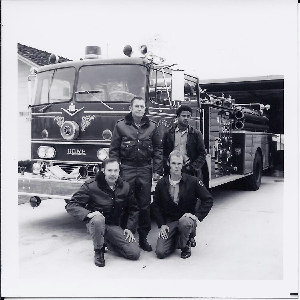 black and white picture of the4 member crew in front of the facility standing in full uniform