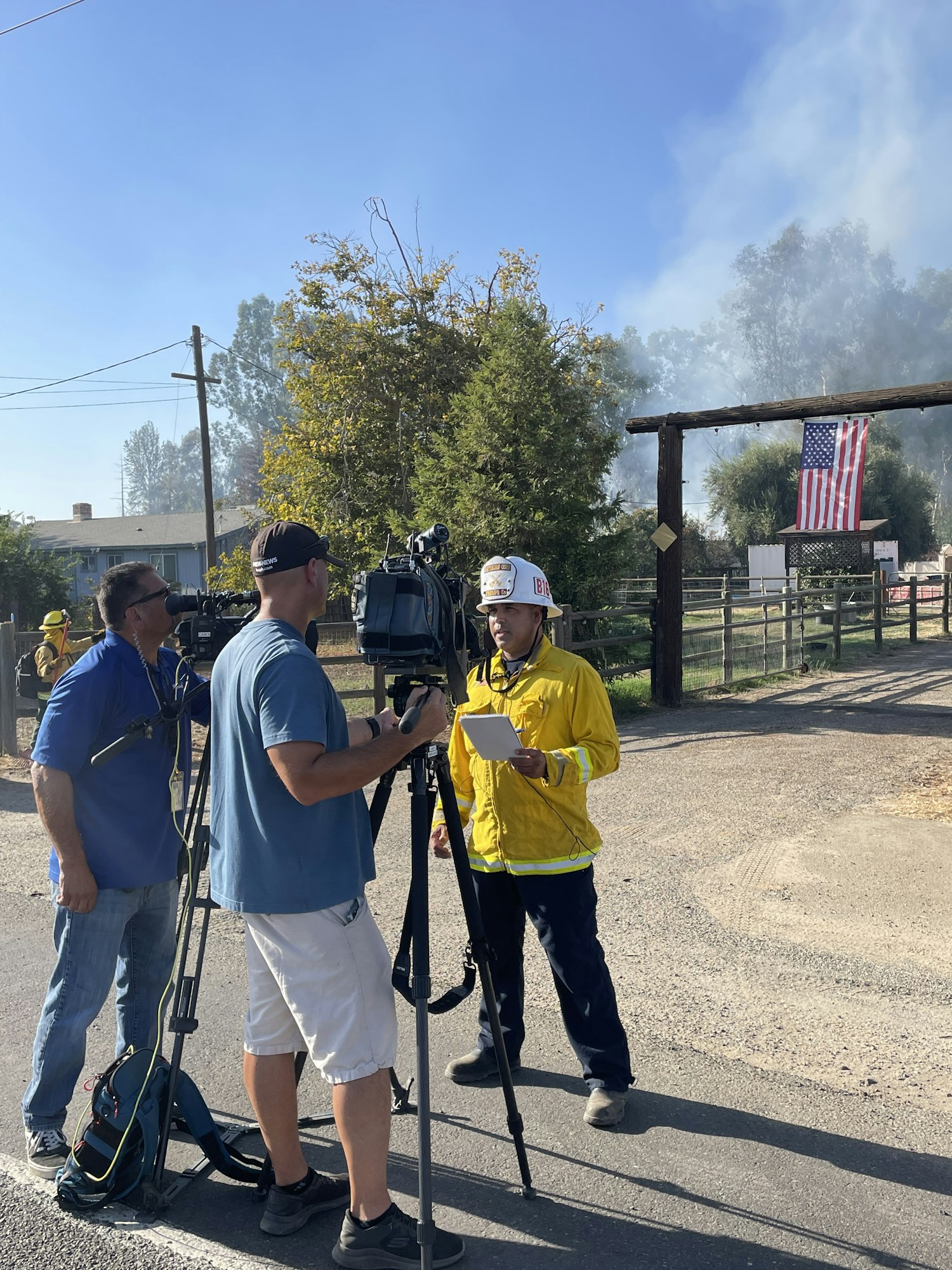 News media with cameras interviewing a Fire Department spokes person the PIO, Public Information Officer